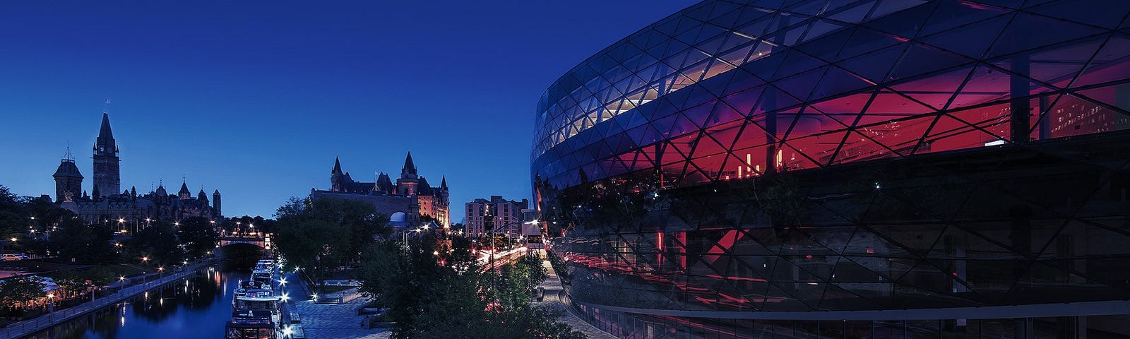 A Zoom background image that is an evening shot of the original conference venue: the Shaw Centre Ottawa beside the Rideau Canal.