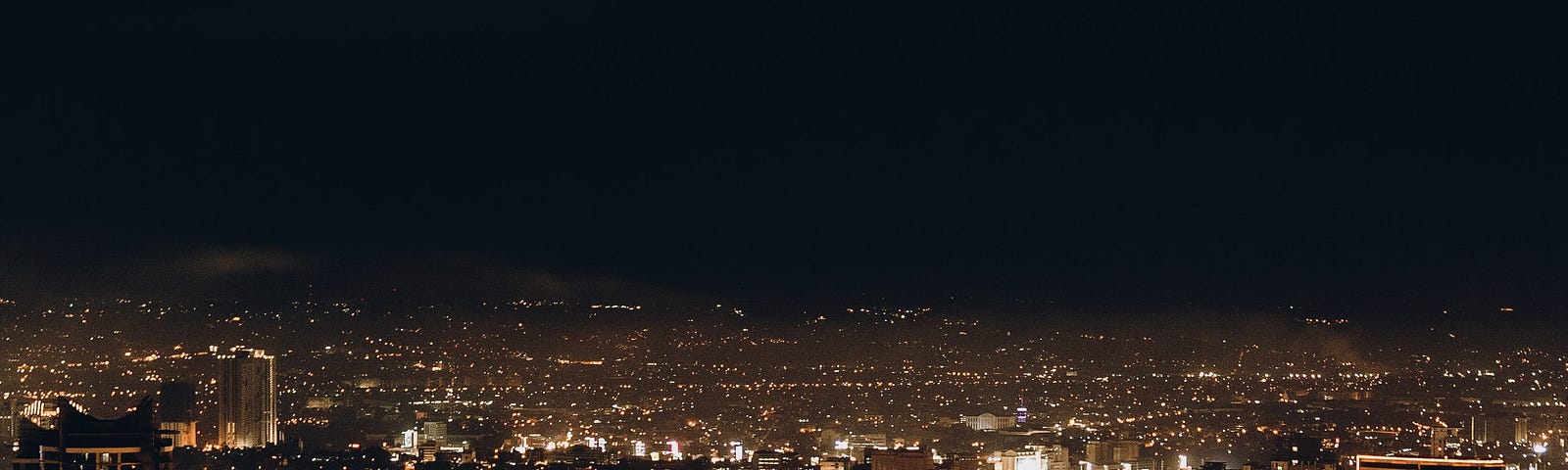 A city landscape at night with neon line accents added on the outlines of the buildings