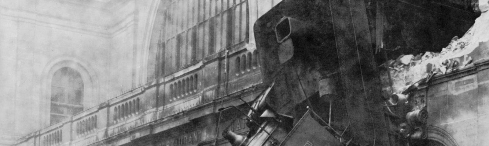 Train wreck at Montparnasse station: train extends through wrecked upper floor wall, awkwardly angled downward towards the street exactly as a train shouldn’t