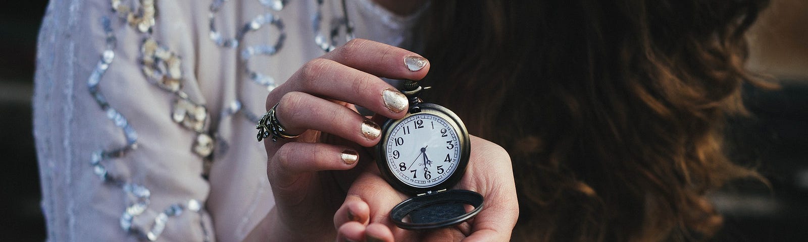 Woman in white top holding an open chain clock
