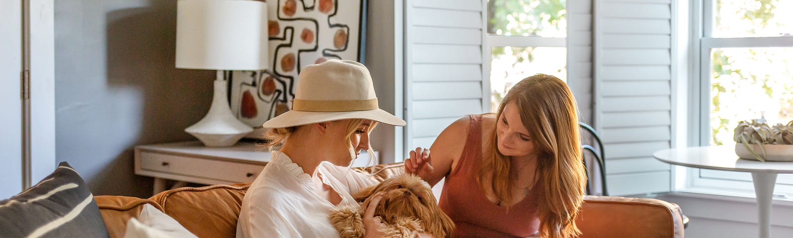 Blueground’s interior design team playing with a cute puppy on a designer couch