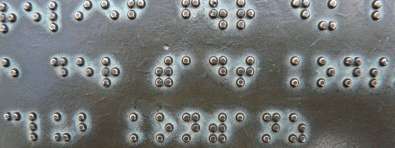 Plat bertulisan braille.