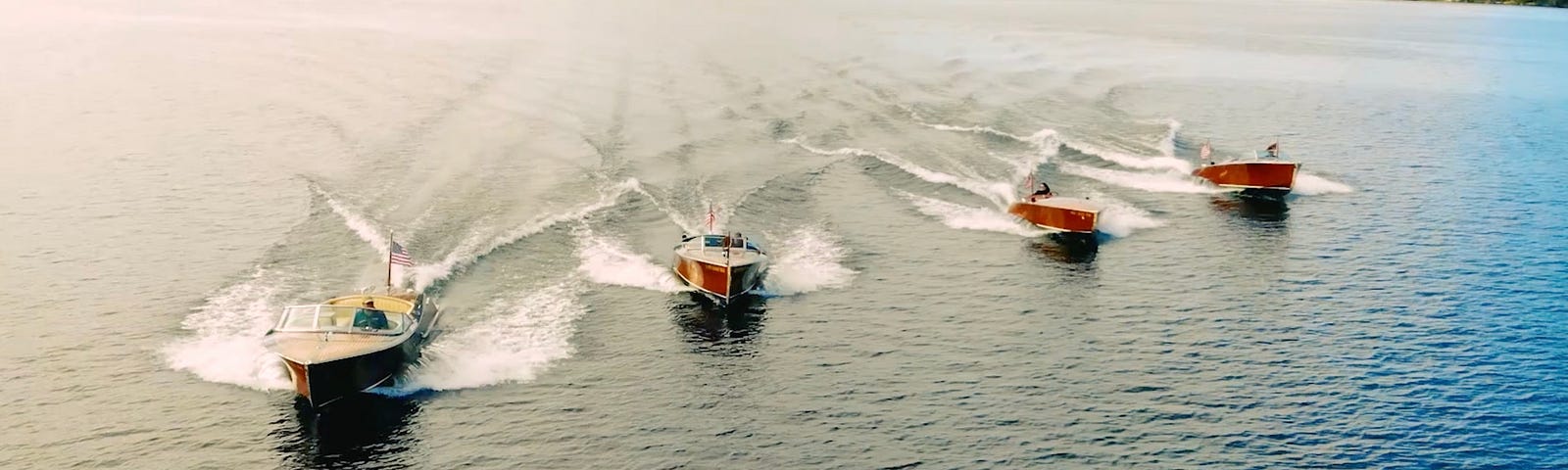 Hacker-Craft Aquavant line of electric wooden luxury boats cruising along on the open water.