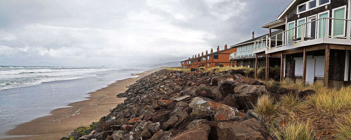 Oceanfront homes with boulders piled along the front to protect them from erosion.