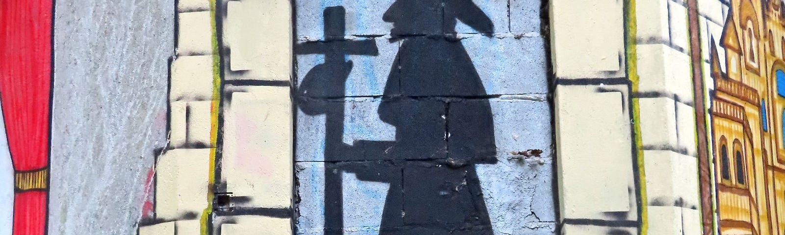 Wall art shows a silhouette of St. James, wearing a long robe and a wide-brimmed hat. He holds a staff with a cross at the top and a small bag that is attached