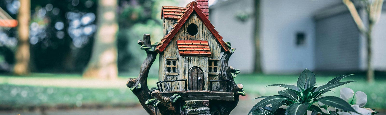 Photo of a birdhouse that looks like a little old house