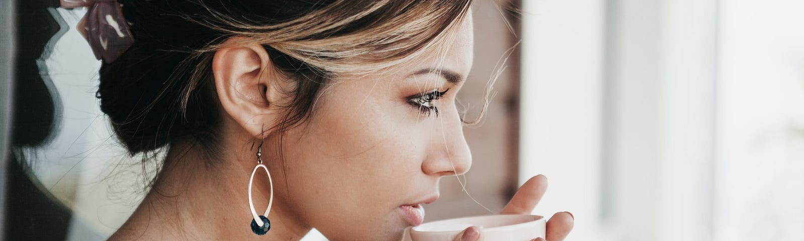 A woman drinking coffee, which is full of caffeine.