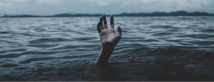 Man drowning, with only his hand remaining above water.
