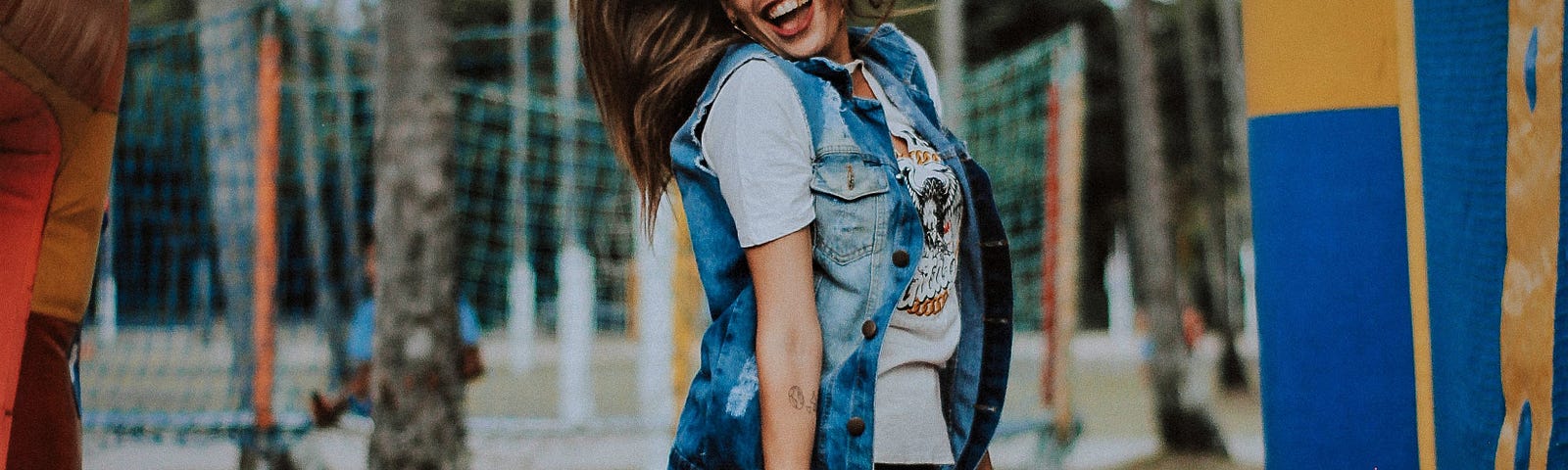 smiling girl with brown hair wearing glasses and shots jumping in the air