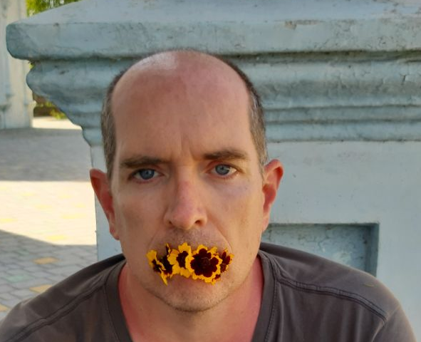 photo of the author with a sunburn and flowers in his mouth