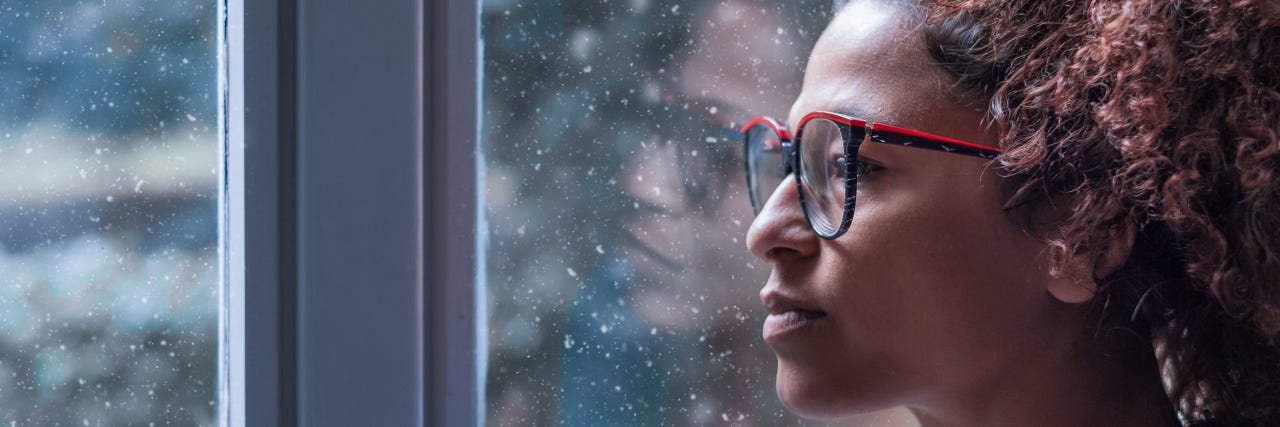 Lady with glasses looks out of the window