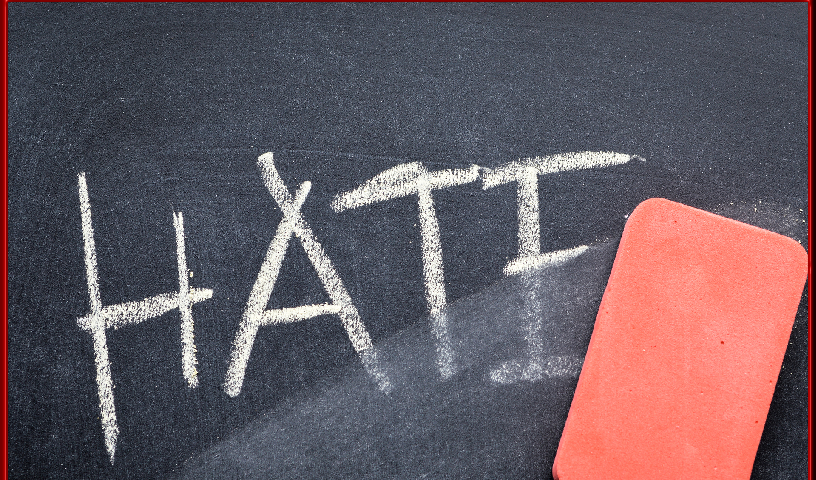 Erasing hate, hand written word on blackboard being erased