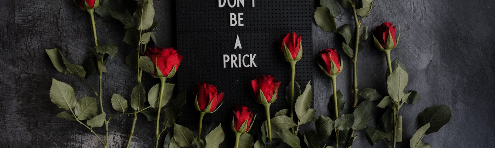 sign that says don’t be a prick surrounded by roses