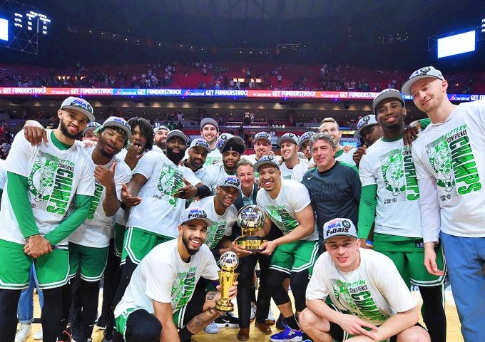 Boston Celtics com o troféu Bob Cousy (ex jogador do Celtics) e Jayson Tatum com o troféu Larry Bird (ex jogador Celta)