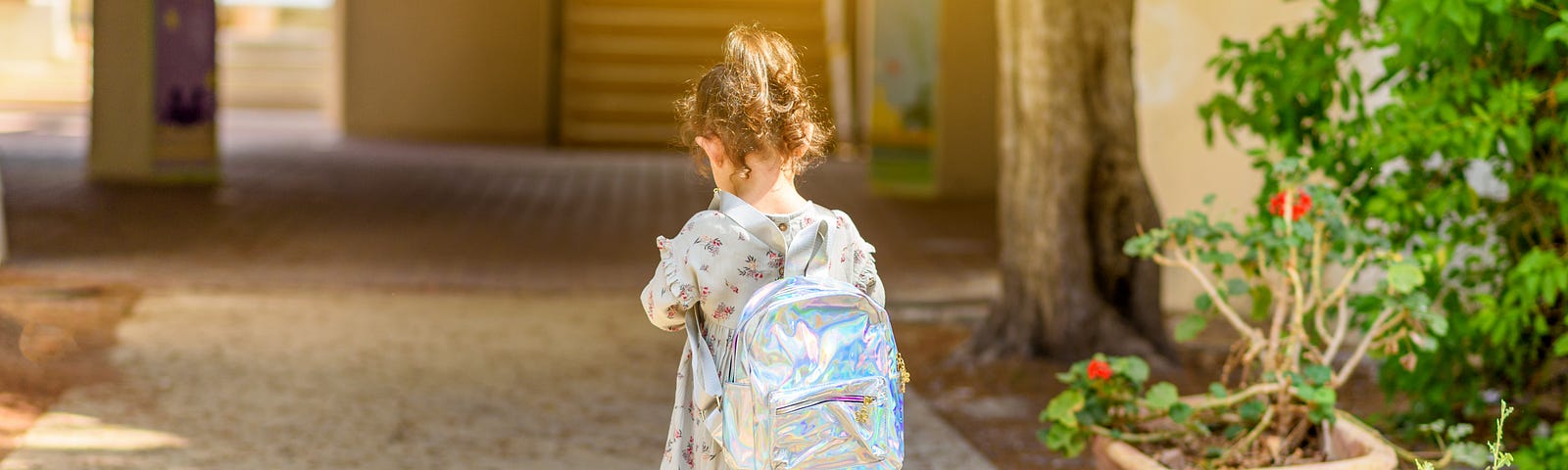 little girl walking into first day of kindergarten