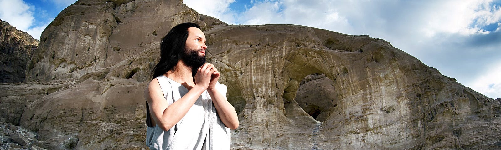 A depiction of Jesus: a bearded man with long hair kneels praying on a dusty ground with a bare mountain behind him.