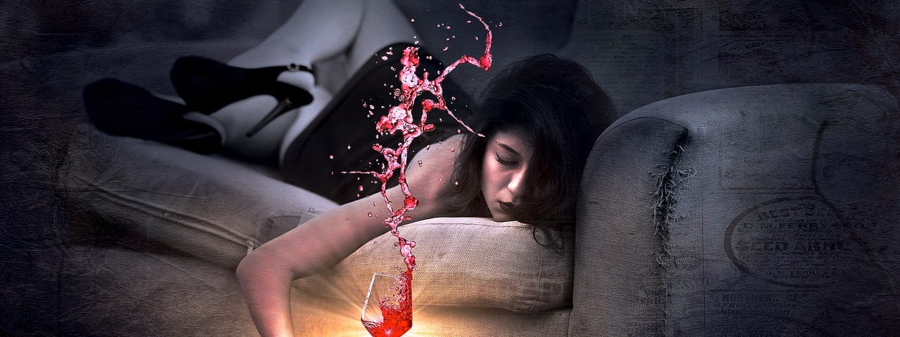 A drunken woman unconscious of a couch while holding a glass of spilt red wine.