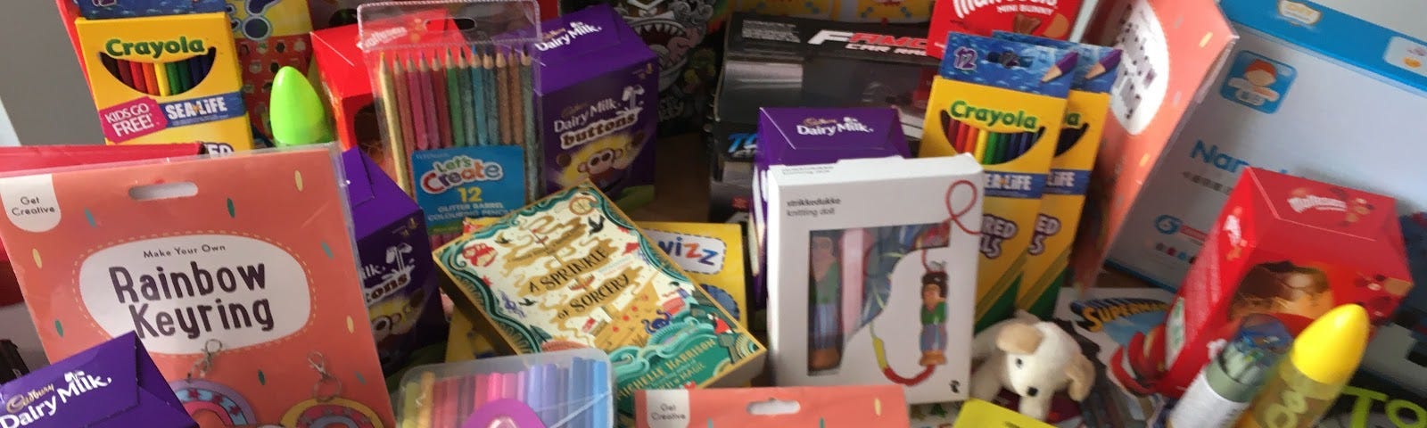 A selection of treats for VIP+’s Children including art supplies and easter eggs all laid out on a table.