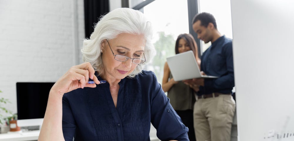 Mature businesswoman working with documents while sitting at her workplace