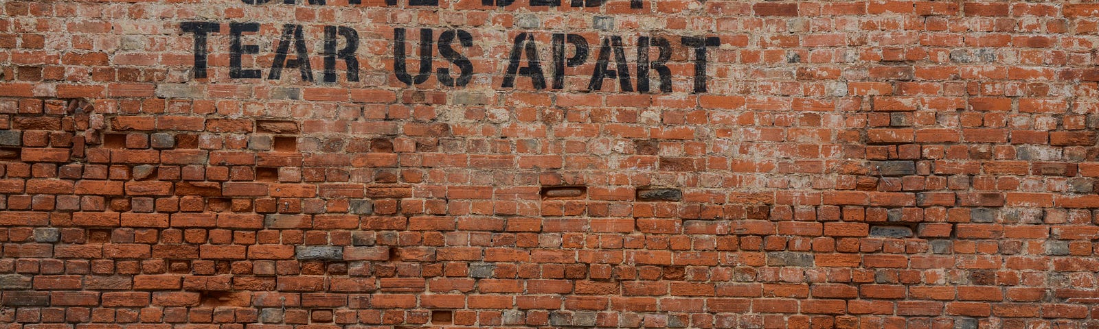 Wall with until debt tear us apart painted on it