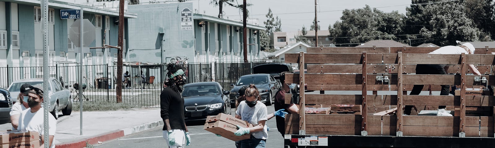 People unloading a truck full of food donations.