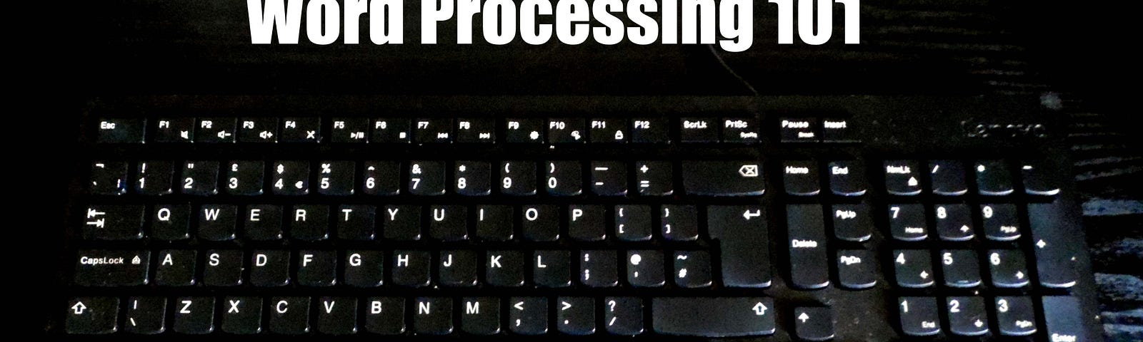 A black computer keyboard with white letters on a black desk. Caption reads Word Processing 101.