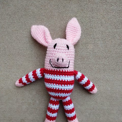 Olive the crochet pig in red and white pajamas