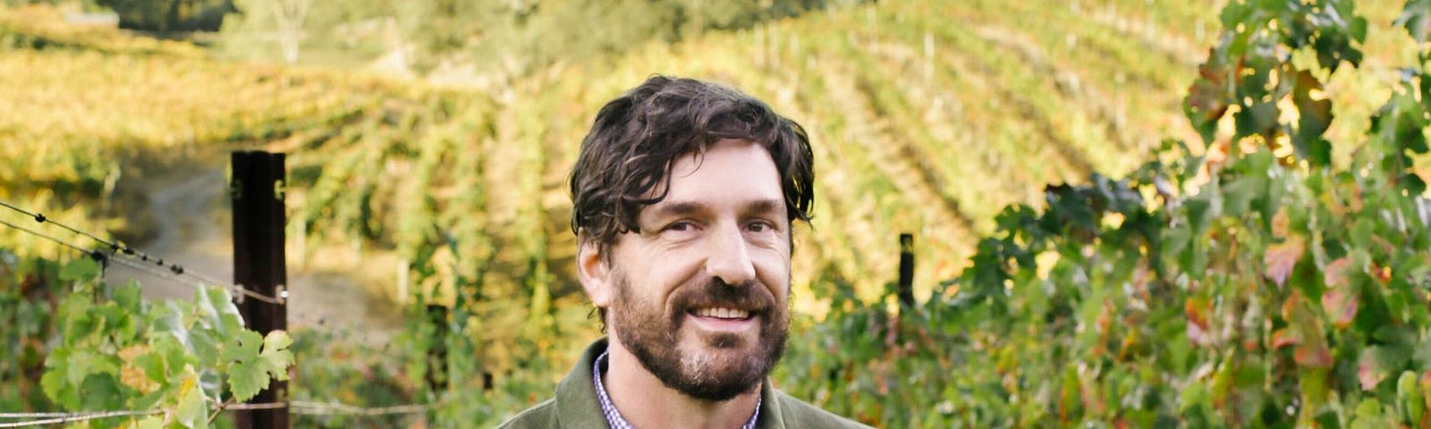 Man standing in middle of grape vineyard