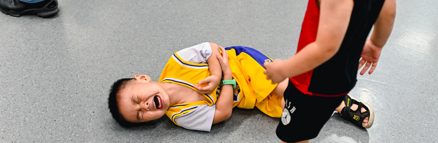 Boy laying on the ground in pain