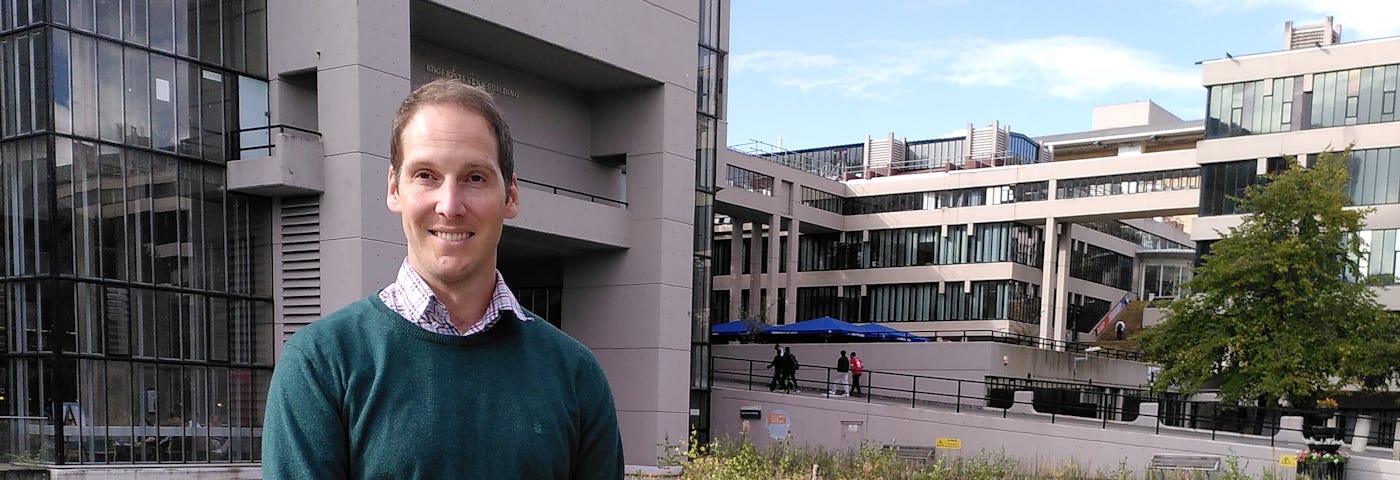 Dr Owen Jackson stood in front of a pond on the University of Leeds campus.