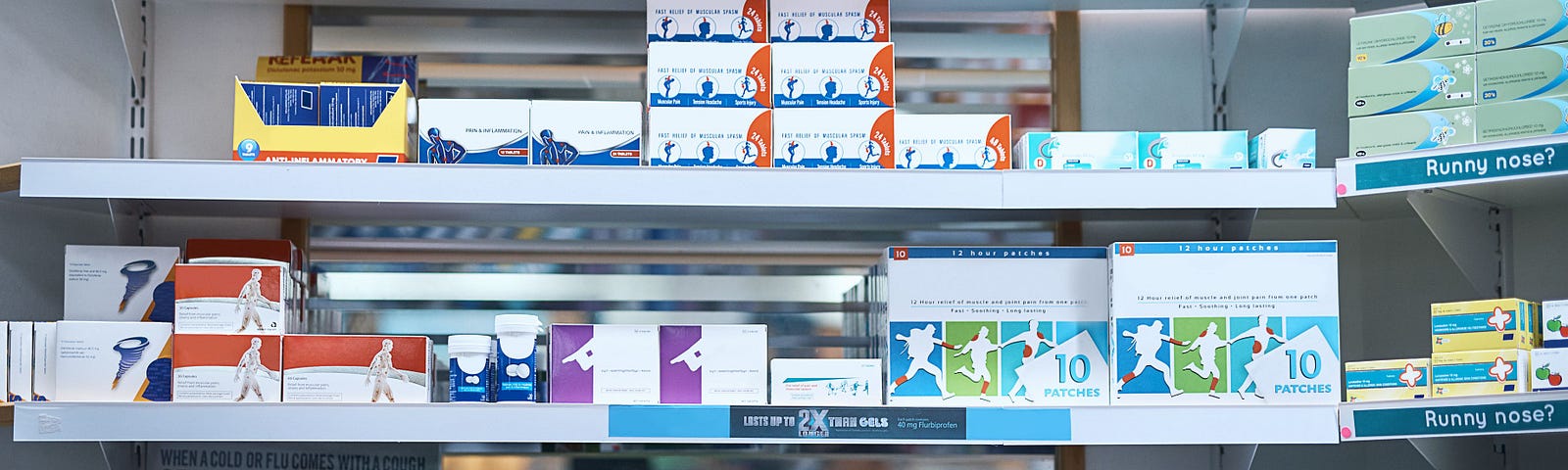 Boxes of medicines on shelves of a pharmacy.