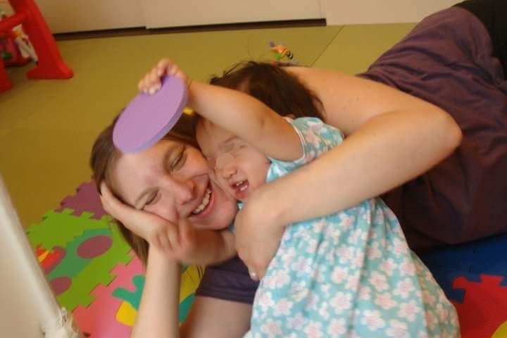 Photo of me and my daughter when she was 1 years old, we’re lying on the floor together laughing.