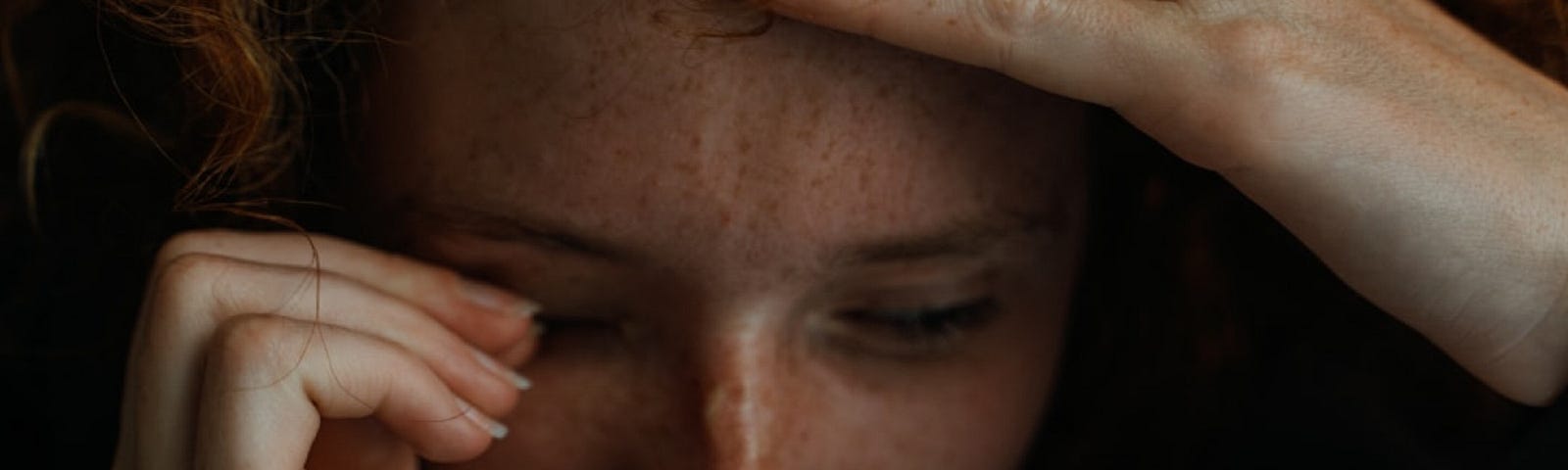 Tom Caillarec took this photo of an emotional woman with her hands on her forehead.