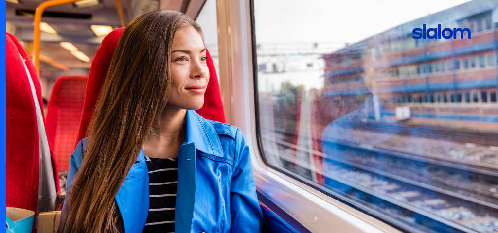 A woman traveling on a train, looking out the window.