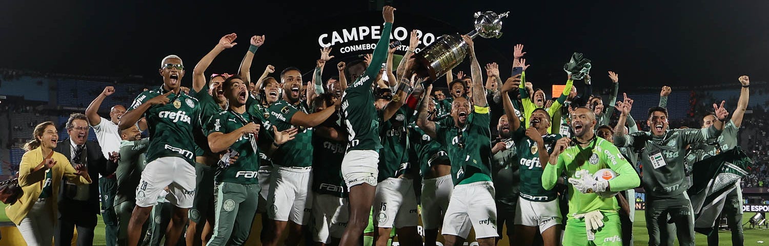 Jogadores do Palmeiras erguem a taça da Libertadores após a vitória sobre o Flamengo por 2 a 1, no Estádio Centenário, em Montevidéu. Jogadores comemoram e saltam, Felipe Melo carrega a taça