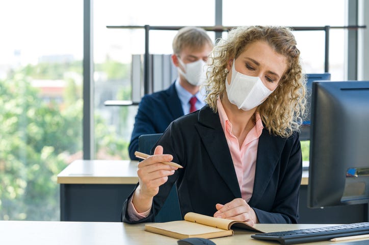 people working in an office with masks — social distancing