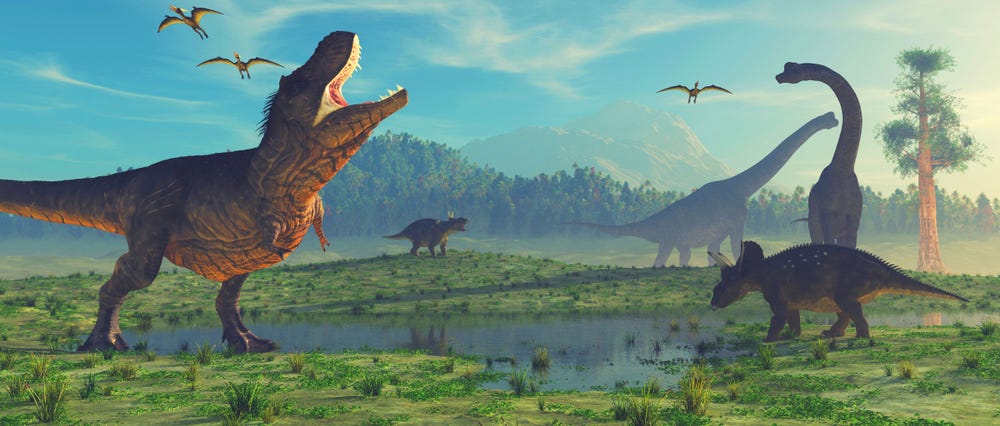 Illustration of different types of dinosaurs in a green landscape with mountains in the background.
