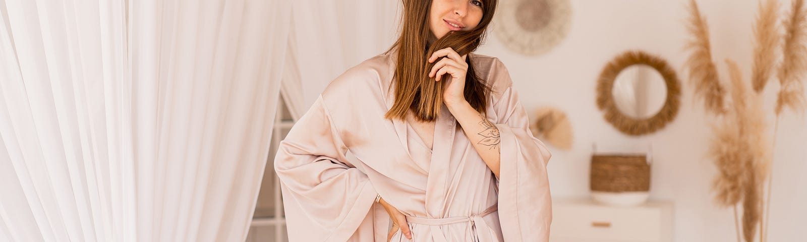 This photo shows an attractive woman in a robe in a bedroom.