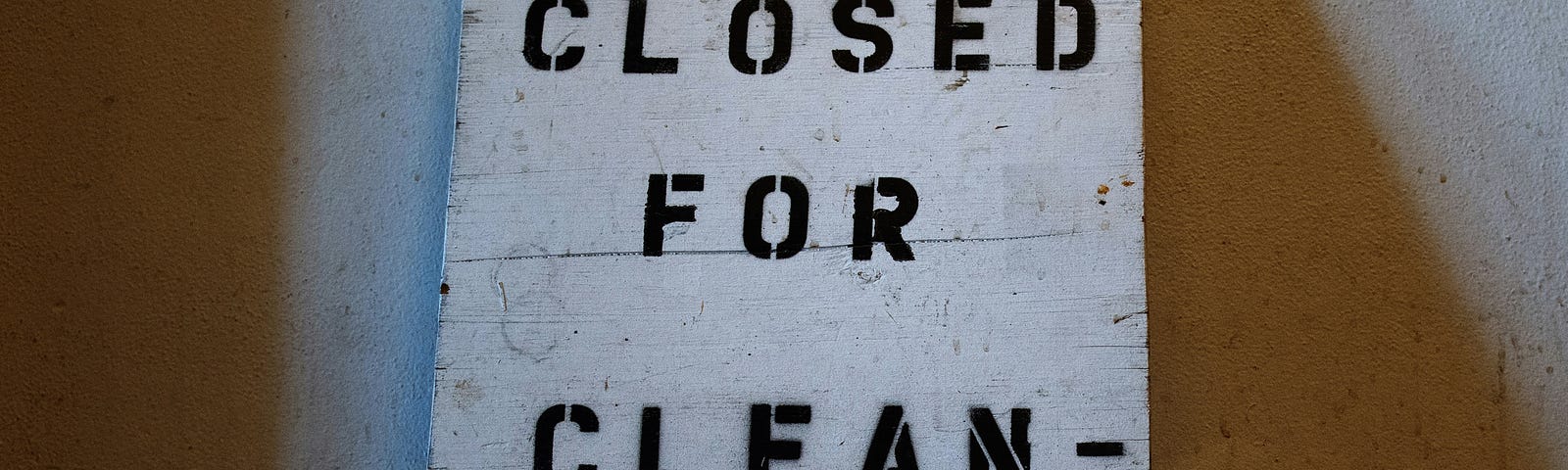 A simple white sign with black writing. Closed For Cleaning.