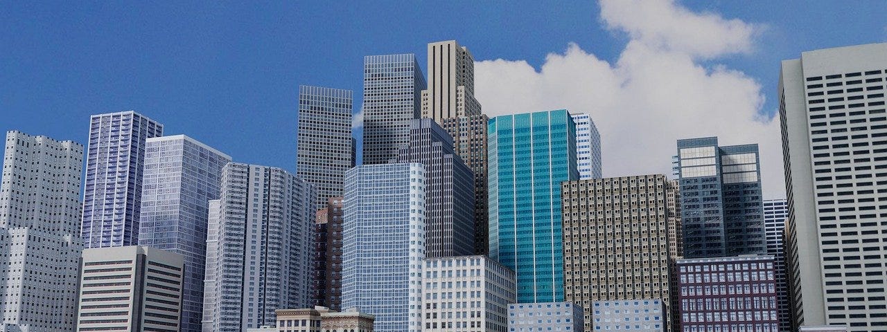 City buildings against a blue sky with a few clouds.