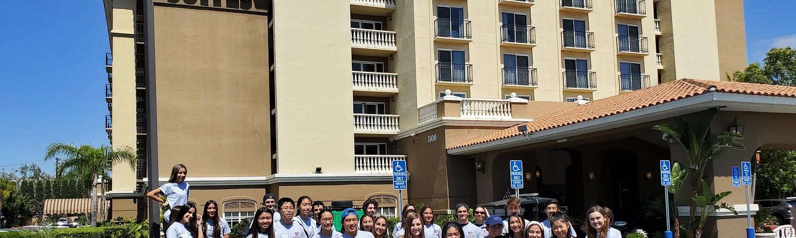 A group of Linens N Love volunteers standing outside of an Embassy Suites building.