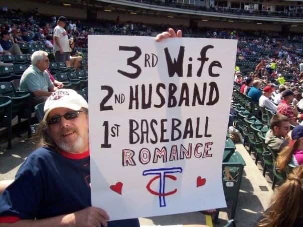 Judd holding sign for Cleveland/Toronto trip: ‘3rd wife, 2nd husband, 1st baseball romance