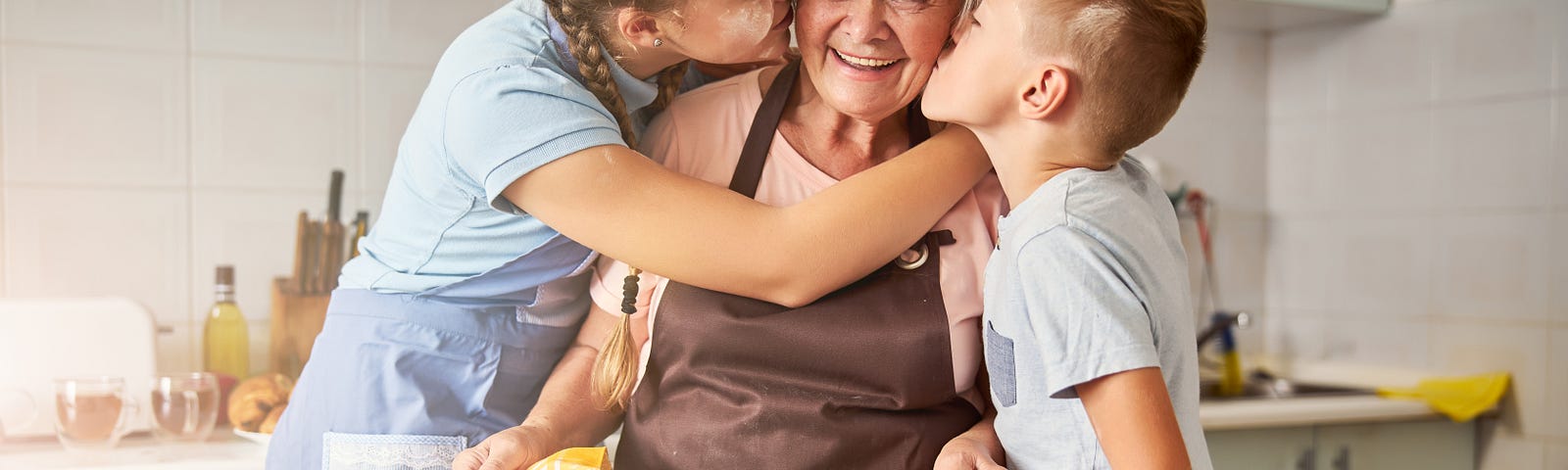 A grandmother being kissed on both sides by grandchhildren