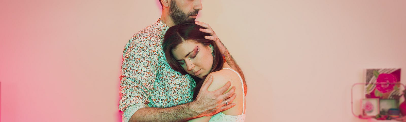 a woman, the author, relaxes in the embrace of a man, her partner.
