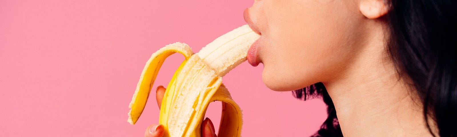 a woman sucking a banana