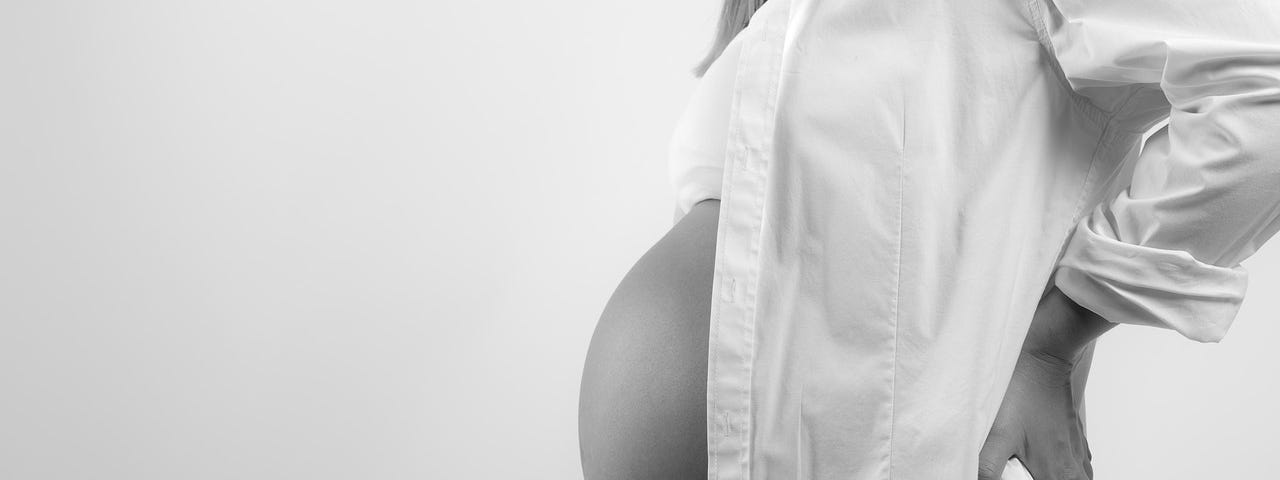 Black and white photo of a very pregnant woman