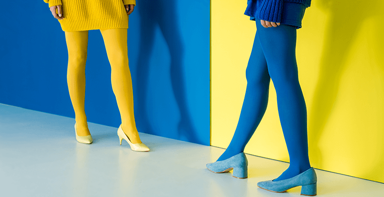 Girls wearing contrasting outfits: blue against a yellow background and yellow against a blue background.