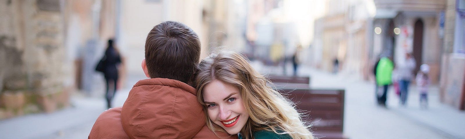 Couple sitting on bench, smiling, sunshine