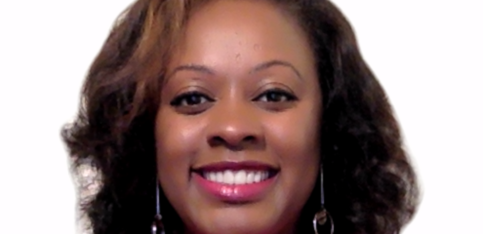 Photo of Alice, a black woman, from the chest up. She is looking at the camera with a wide smile which shows her teeth. She is wearing red lipstick, with a fuchsia top and dangling earrings. Her hair is medium length, dark brown hair and a light brown streak in the front left side.