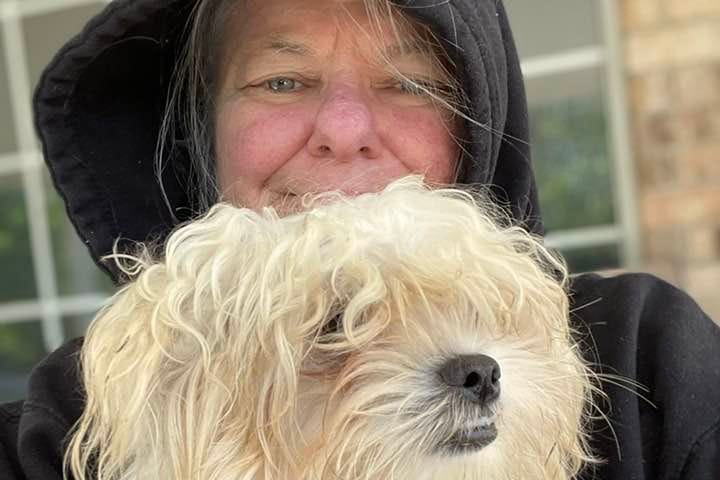 A selfie photo of me and my dog Emmy. She is zipped up in my hoodie with her head sticking out at the top. We are cold!